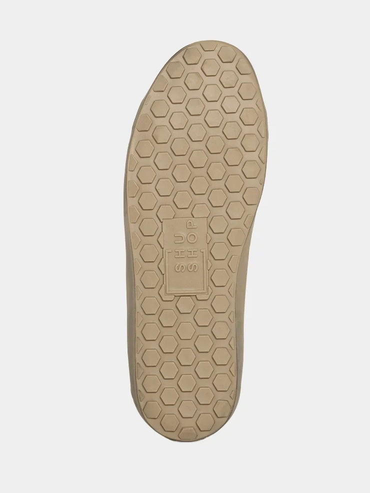 Beige shoe sole with a honeycomb pattern on a white background