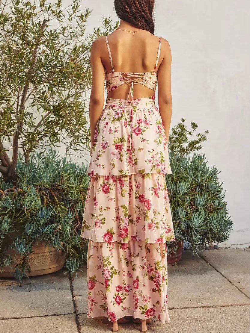 Woman wearing a floral dress with a white wall and plants in the background