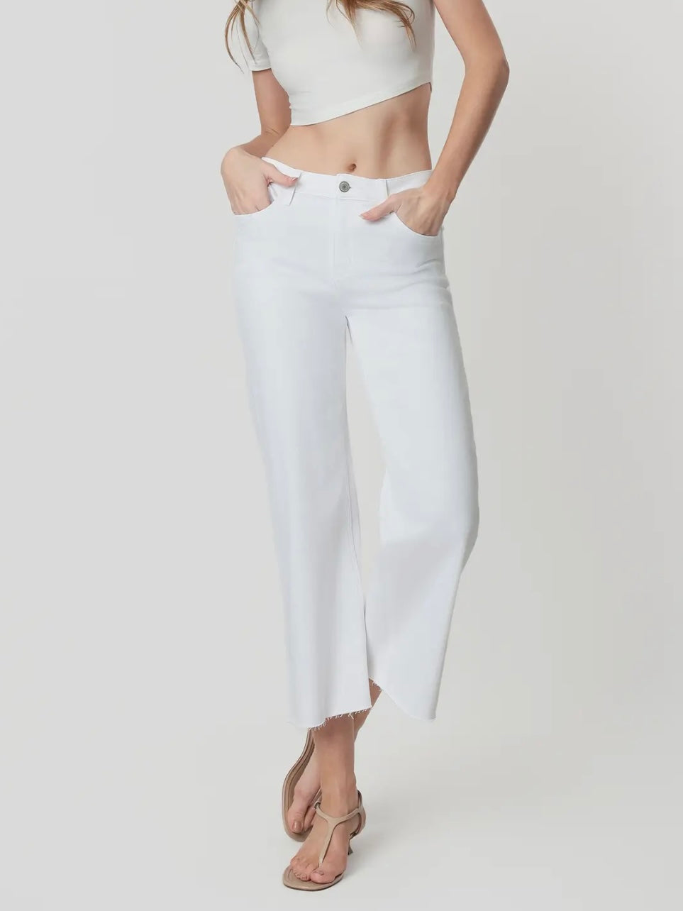 Person wearing white pants and a white top on a plain background