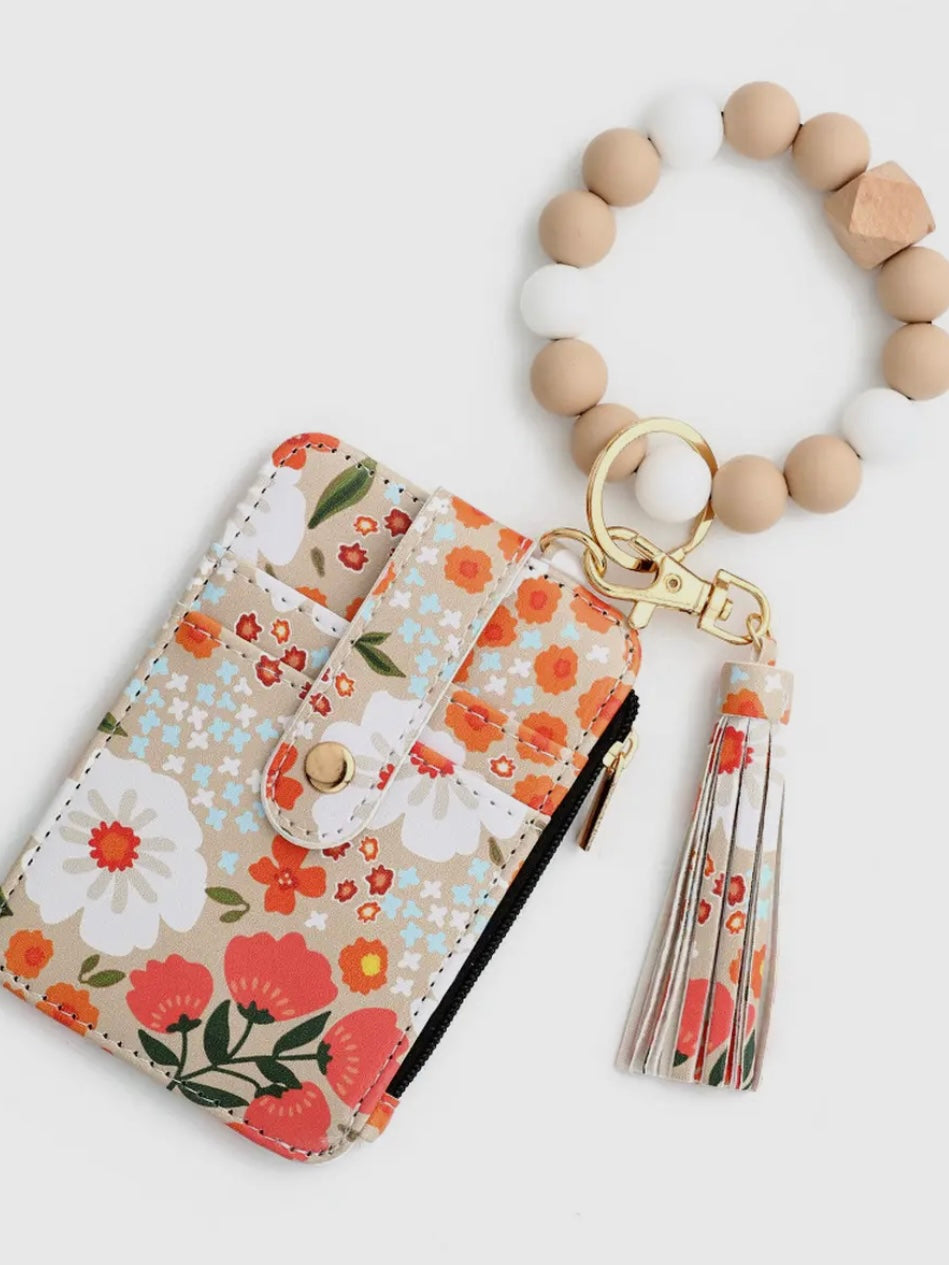 Floral-patterned keychain with beads and tassel on a white background