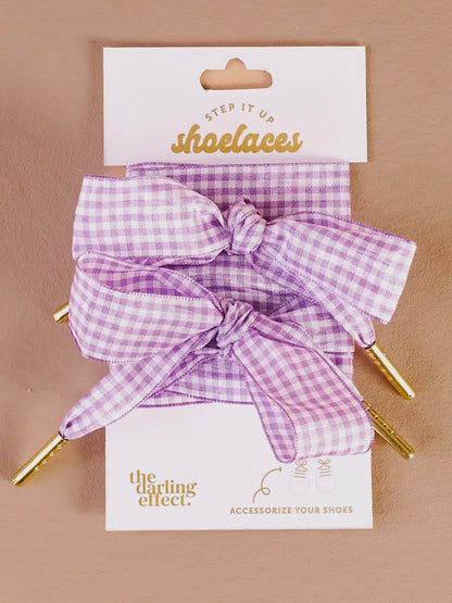 Purple gingham shoe laces with a bow on a 'Step it up shoelaces' card.