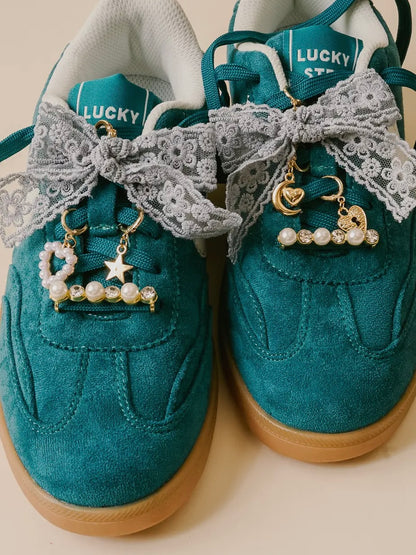 Teal sneakers with lace and charms on a beige background