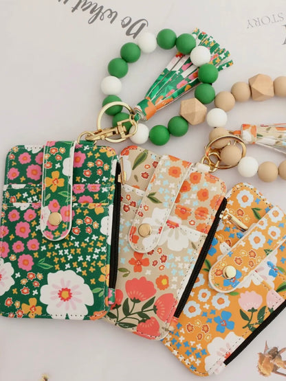 Floral patterned keychains with matching pouches on a light background