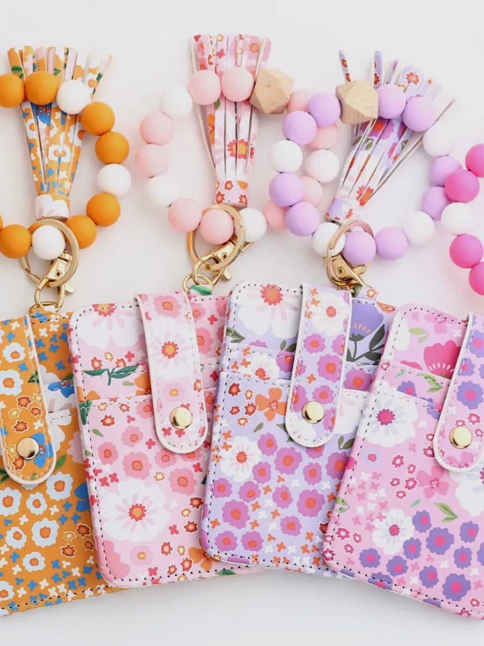 Floral phone cases with colorful lanyards on a white background