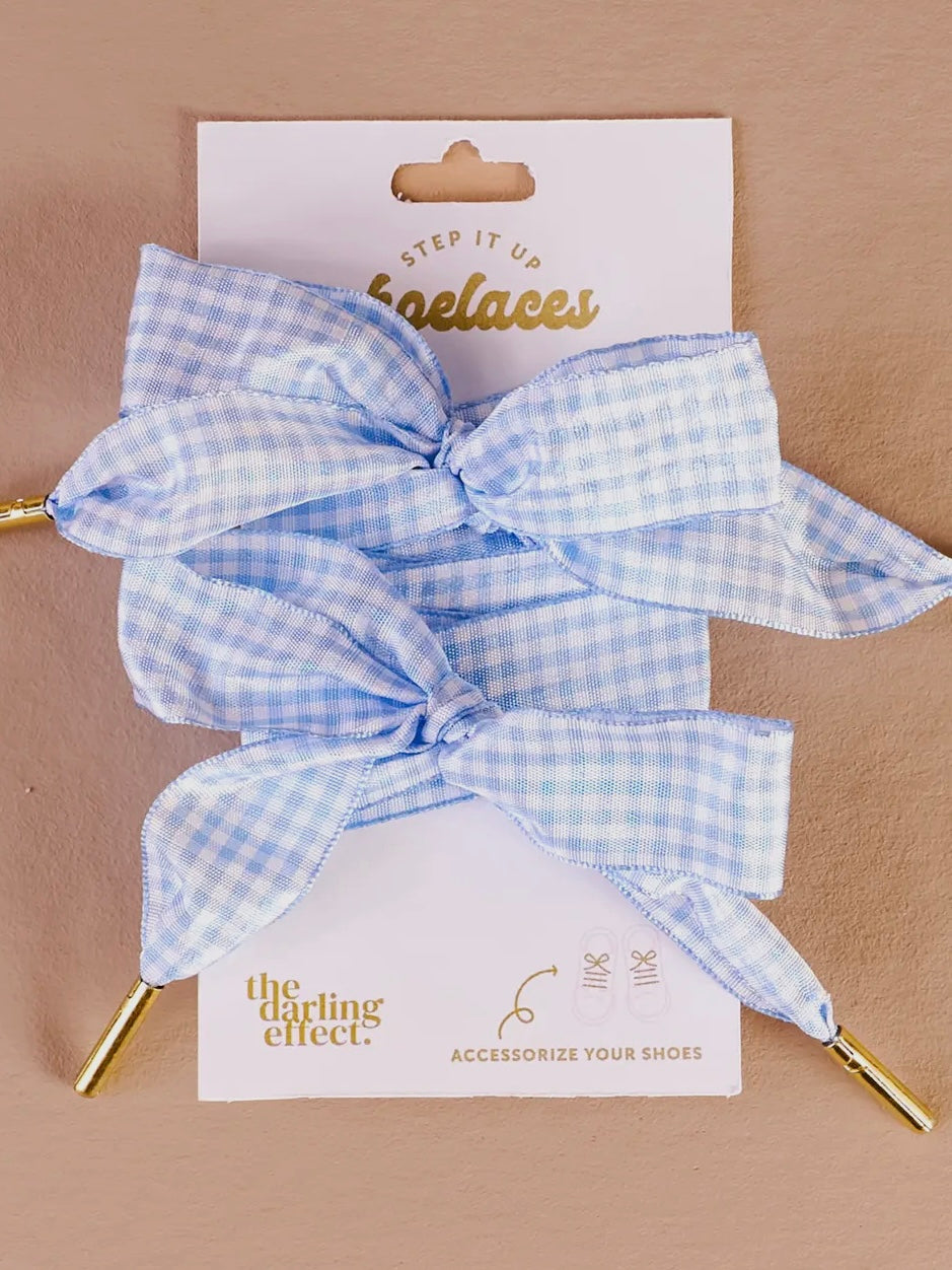 Blue checkered shoelaces on a 'the darling effect.' branded card against a beige background