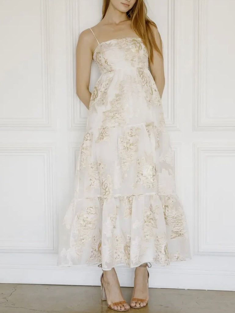 Woman wearing a white lace dress against a white wall