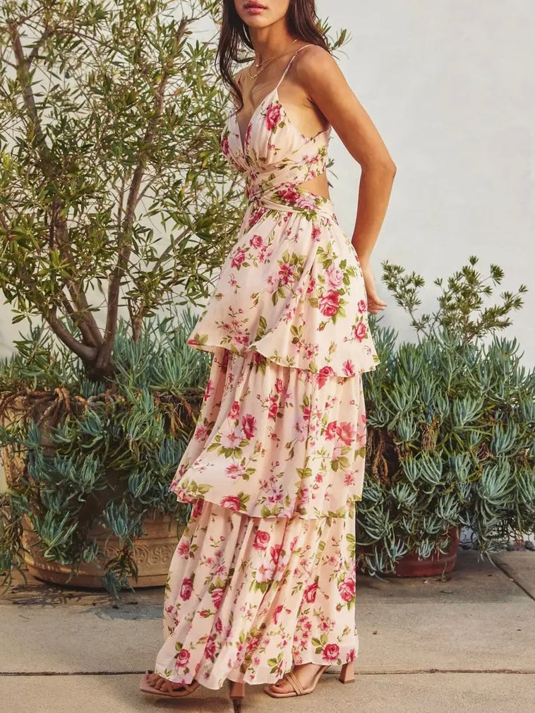 Woman wearing a floral dress standing outdoors with plants in the background
