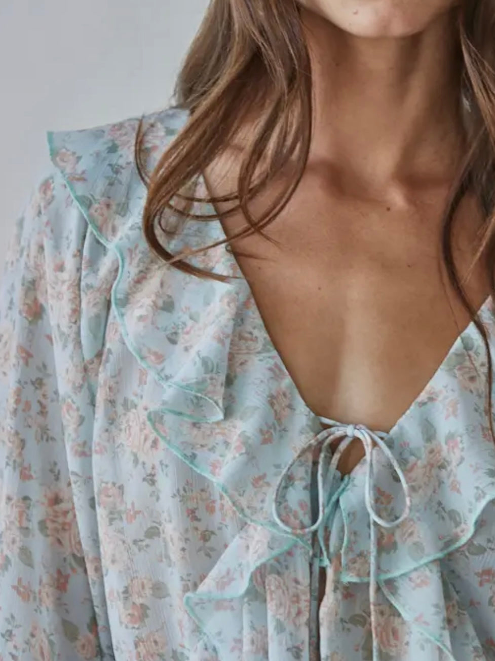 Light blue floral dress with a deep neckline on a plain background