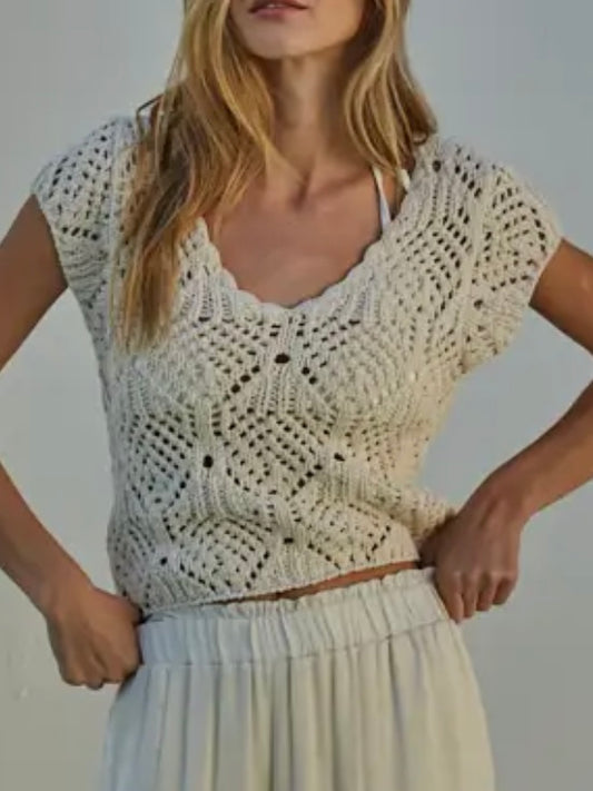 Woman wearing a crochet top and skirt against a plain background