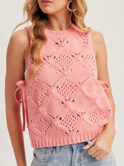 Woman wearing a pink sleeveless knitted top on a white background