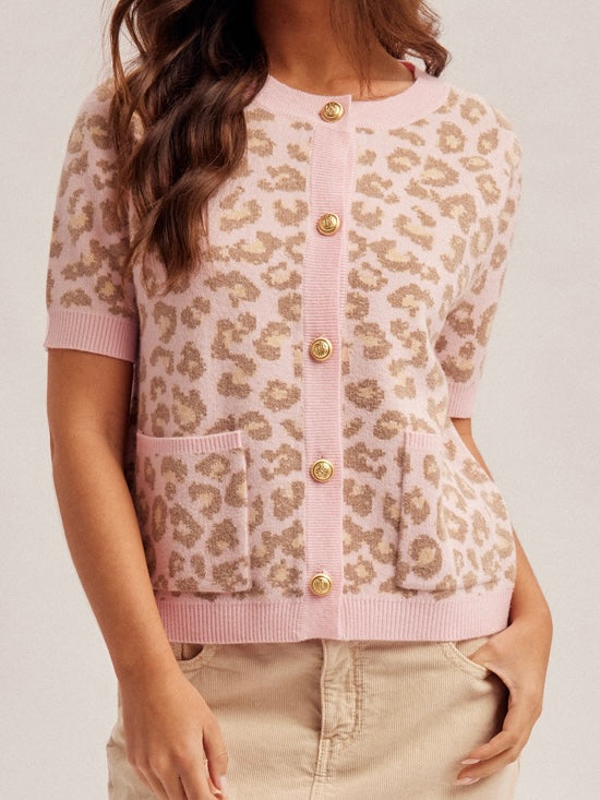 Pink cardigan with leopard print and gold buttons on a plain background