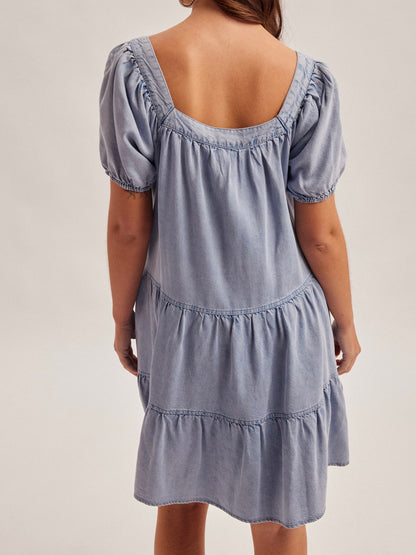 Blue denim dress with puff sleeves on a plain background