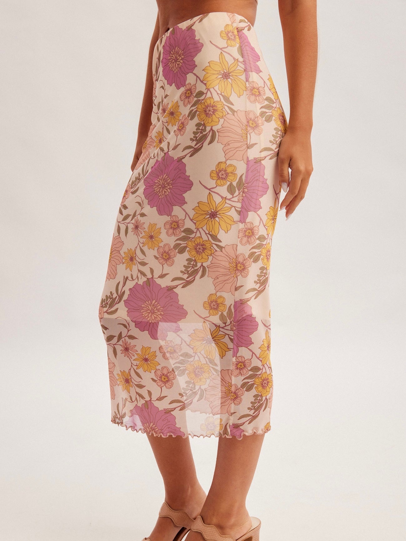 Floral patterned skirt worn by a person on a white background