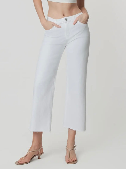 White jeans worn by a person on a plain background