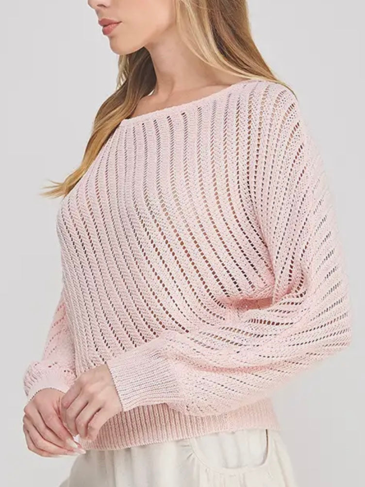 Woman wearing a light pink knit sweater against a plain background
