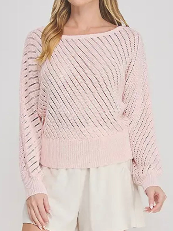 Pink knitted sweater worn by a person on a white background