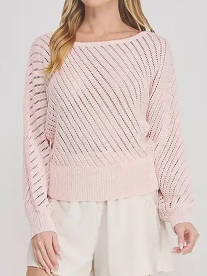 Pink knitted sweater worn by a person on a white background