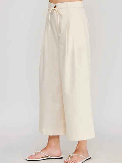 Beige wide-leg pants on a plain background