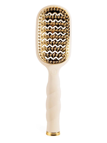 An oval-shaped hairbrush with a cream-colored handle and a gold-toned metal head featuring textured, raised nubs, shown on a solid white background.