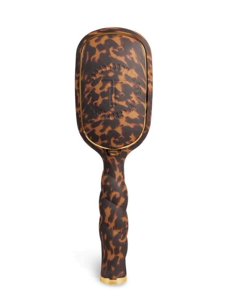 A hairbrush with a brown and black leopard print pattern and gold trim, shown upright on a white background. The brand name 'TIGER' is embossed on the brush head.