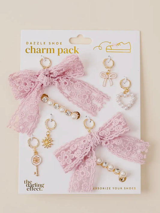 Charm pack with pink bows and gold accessories on a white card