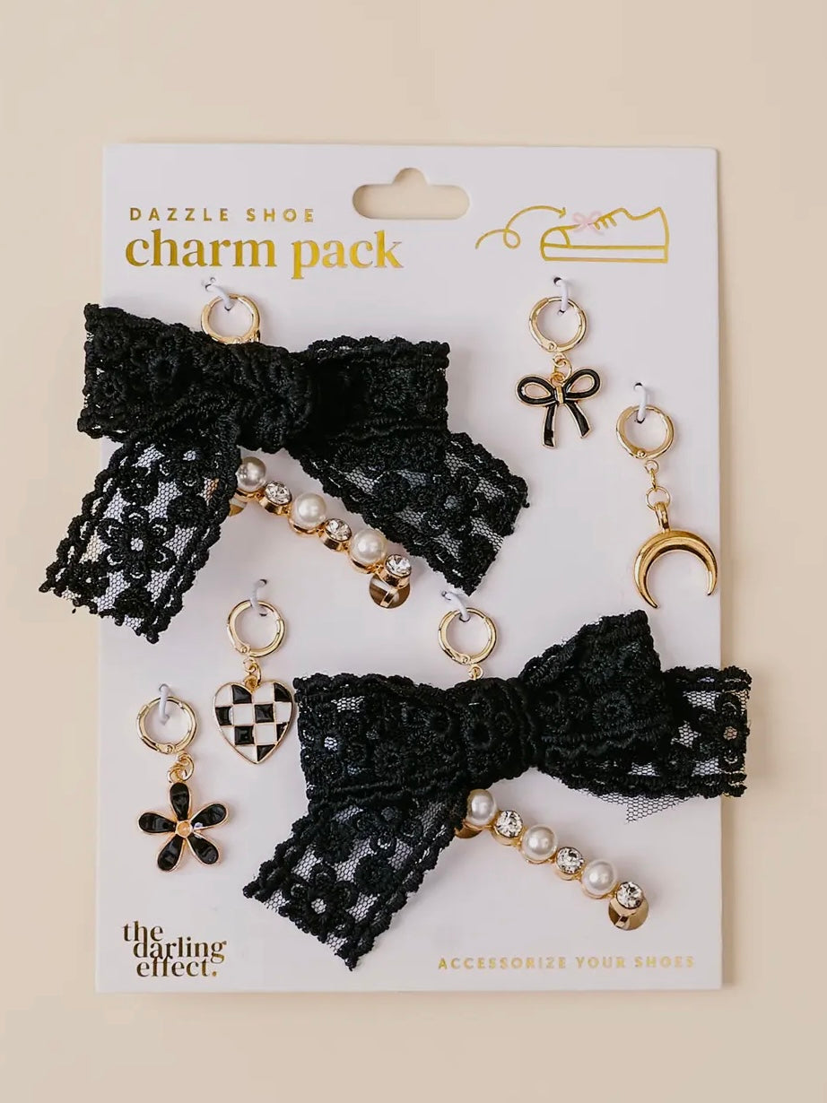 Charm pack with black lace bow and pearl charms on a beige background