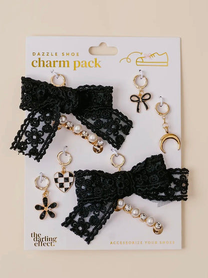 Charm pack with black lace bow and pearl charms on a beige background